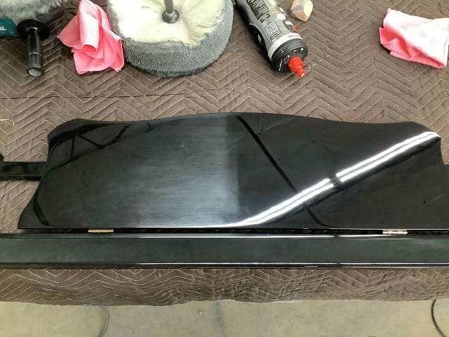 Yamaha piano music rack showing one side polished and the other side unpolished during buffing