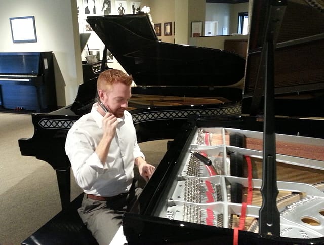Holt Bradfield Deniger tuning a Steinway grand piano at the Steinway & Sons showroom in Dallas, Texas